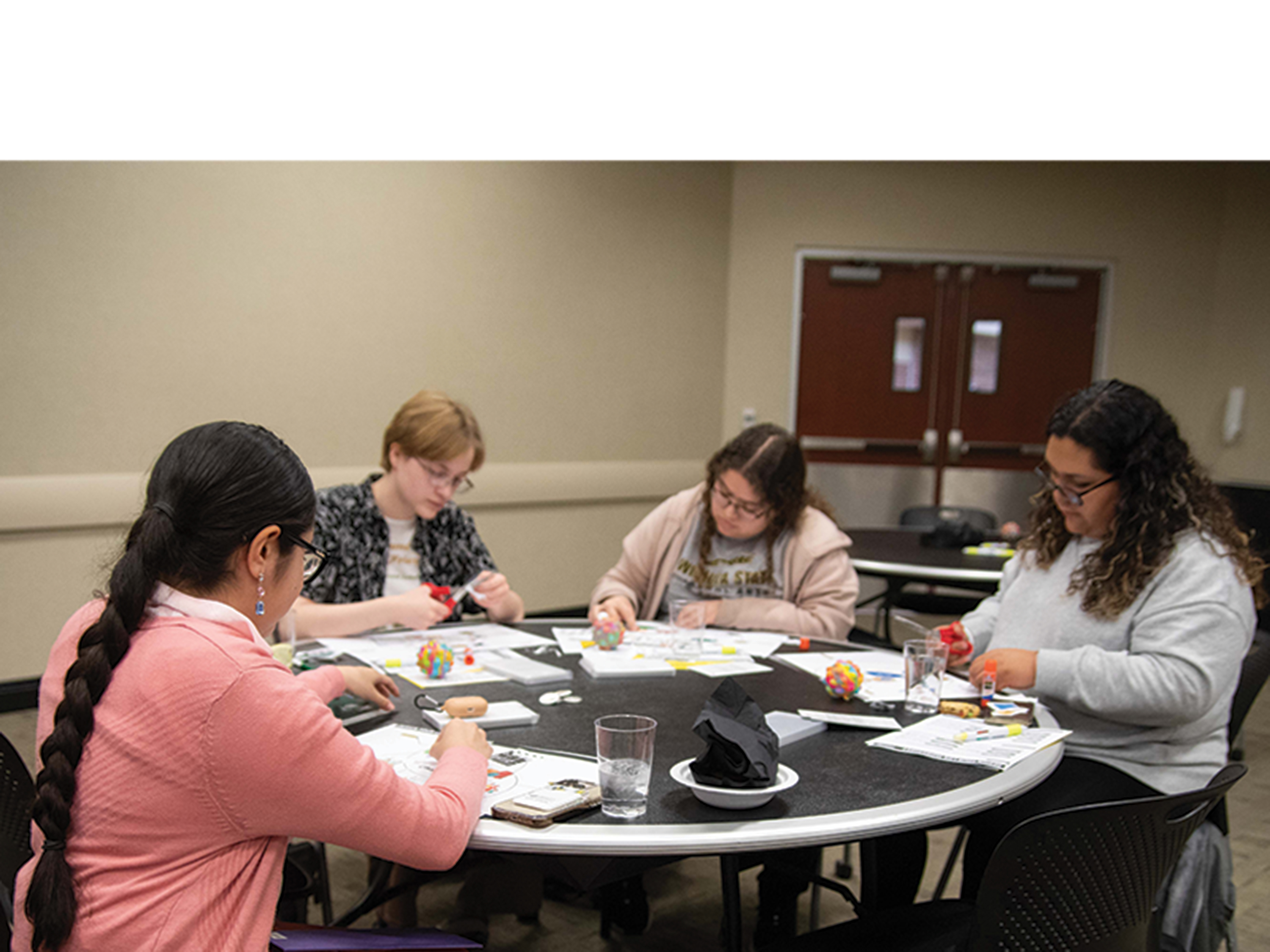 Image of Wichita State students gathered around a table creating design your life diagrams.