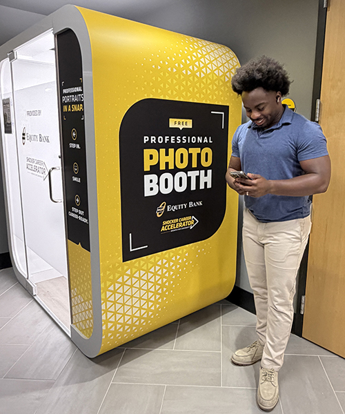 A student seated inside the Shocker Career Accelerator photo booth.