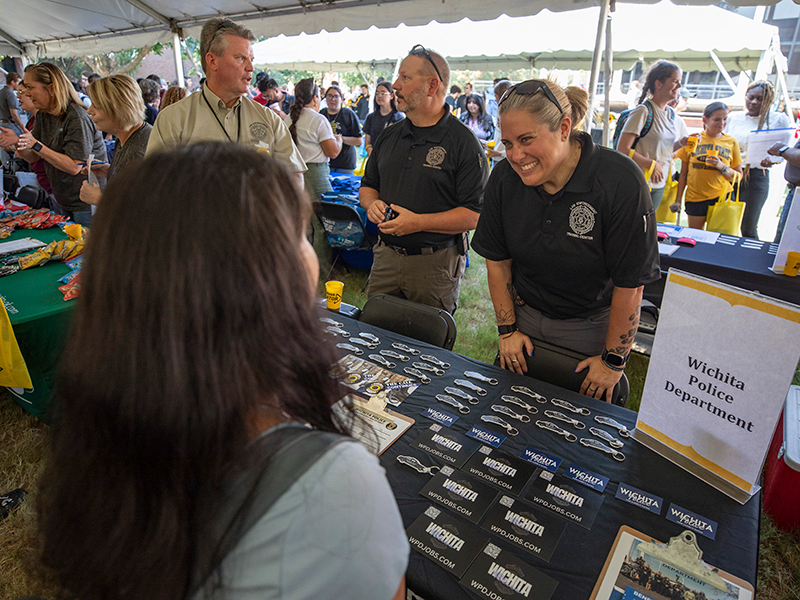 Image of Wichita Police Department employers talking to students at the Kegger
