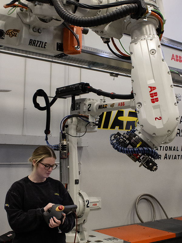 Haylee Thurman works with the robots in the NIAR Automation Research Center.