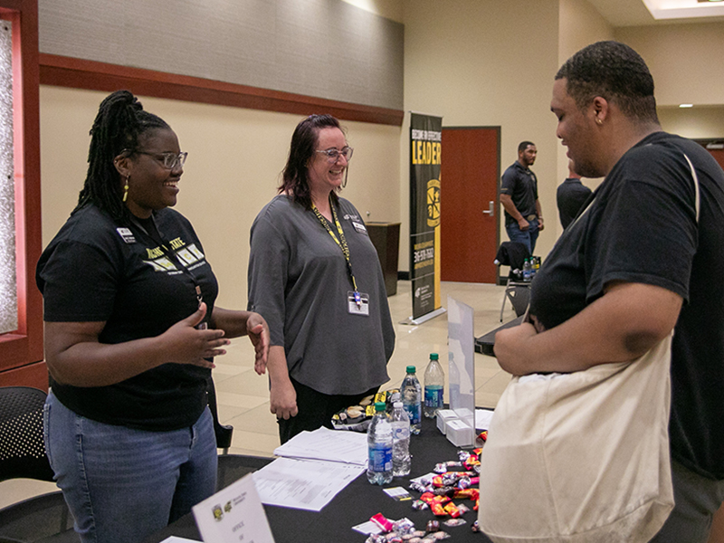 Image of Wichita State staff talking to a student at the on-campus job fair.