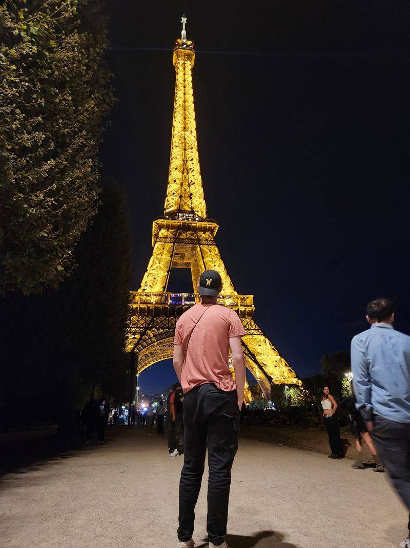 Guy facing the Eiffel Tower at night