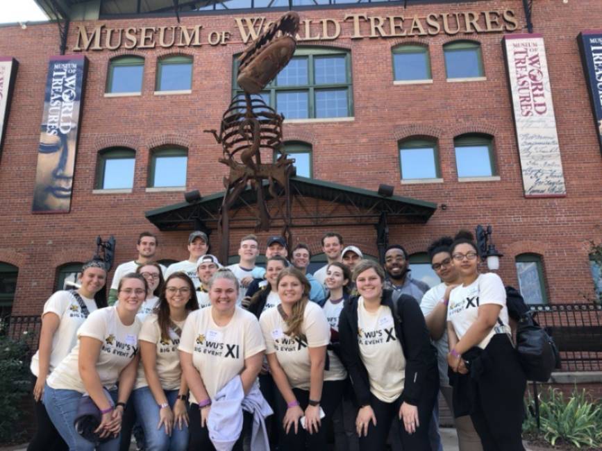 Group photo of volunteers in front of the Museum of World Treasures