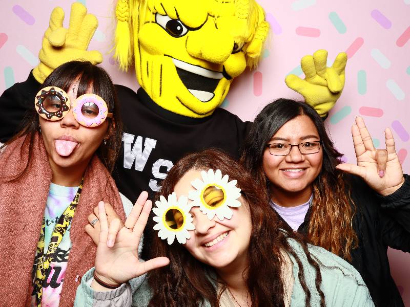 Three students posing for a fun photo with WuShock. 